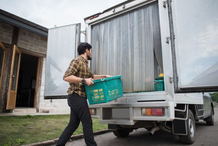 Seorang pekerja tengah memuat barang kedalam mobil box berpendingin